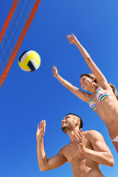 Happy beautiful couple playing volleyball - Фото, изображение