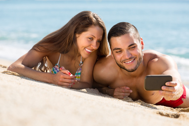Happy couple taking photo on the beach - Фото, зображення