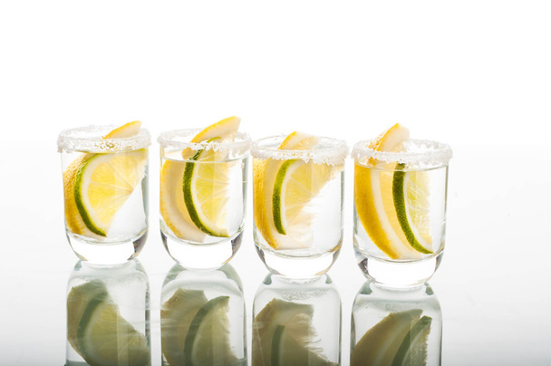 Vier shots van wodka met citroen - Foto, afbeelding