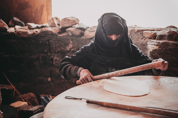 Old Arab woman prepares bread - Foto, Imagen