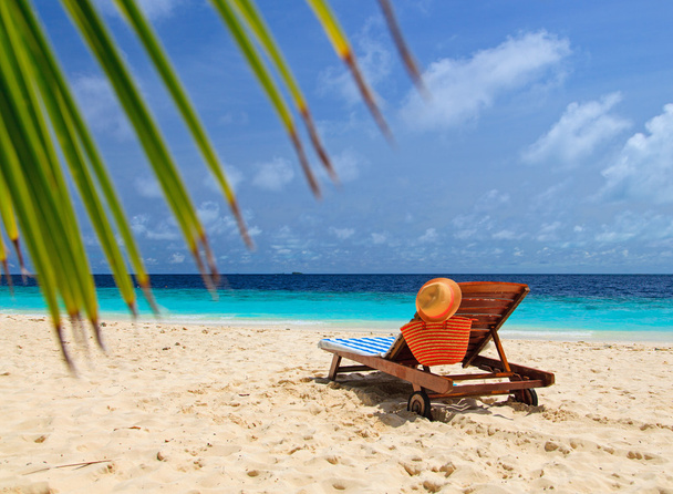 chapeau et sac de paille sur une chaise longue à la plage de sable
 - Photo, image