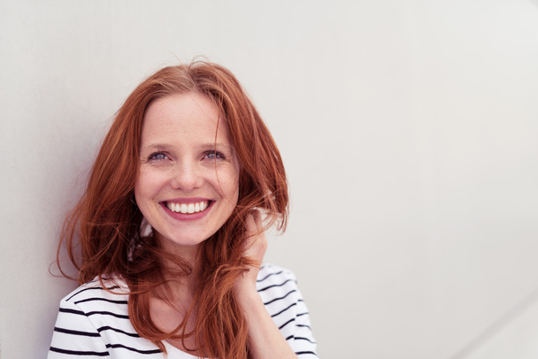 Cheerful Woman Against White Wall Smiles at Camera - Фото, изображение