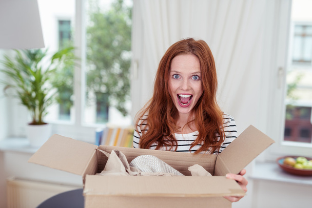 Excited young woman with an opened package - Foto, imagen