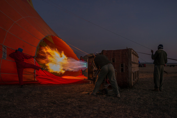Men before dawn inflating hot air balloon - 写真・画像