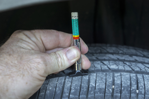 Medición de desgaste de la banda de rodadura en un neumático de coche
 - Foto, Imagen