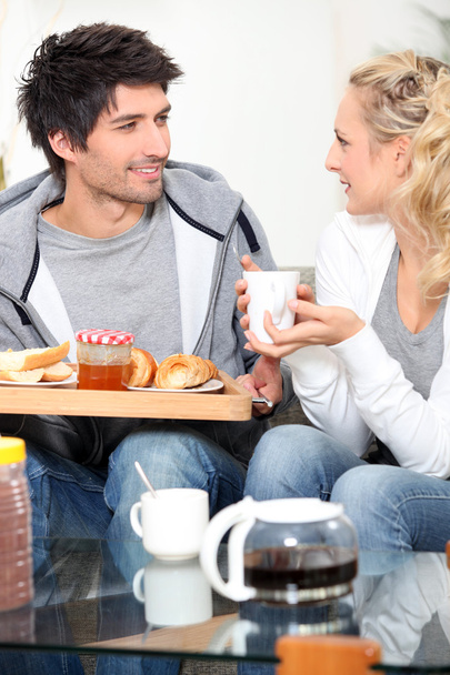 Couple having breakfast together on sofa - Foto, Imagen