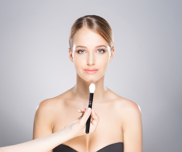Beautiful girl is being applied with cosmetics - Zdjęcie, obraz
