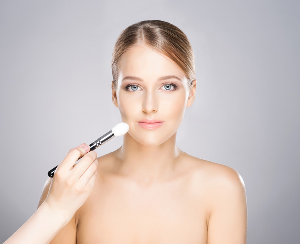Beautiful girl is being applied with cosmetics - Φωτογραφία, εικόνα