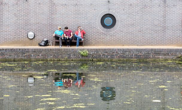 Három srác beszélget csatorna közelében - Fotó, kép