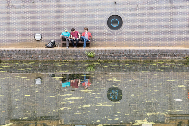 Három srác beszélget csatorna közelében - Fotó, kép