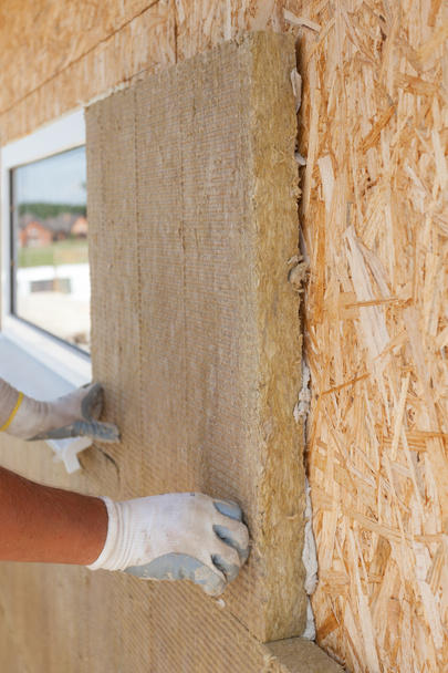 Builder worker installing  insulation material on a wall - Photo, Image
