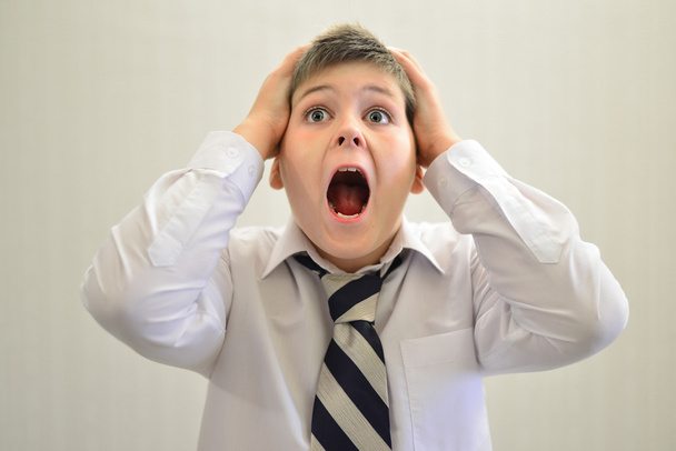 Teen boy screaming holding his hands behind  head - Φωτογραφία, εικόνα