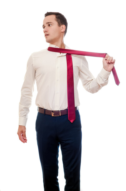 Νεαρός άνδρας αφαιρεί ένα κοστούμι που απομονώνονται σε λευκό. Επιχειρηματίας ή φοιτη - Φωτογραφία, εικόνα