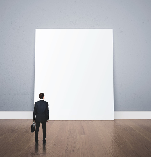 businessman looking at blank poster - 写真・画像