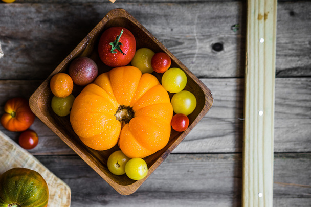Colorful heirloom tomatoes on rustic wooden background - Foto, Imagem