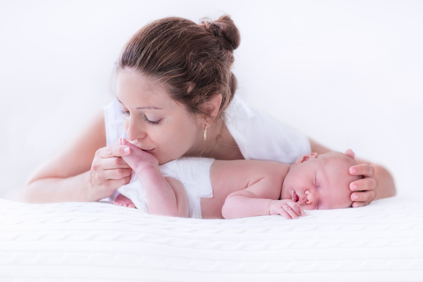 Giovane madre e neonato in camera da letto bianca
 - Foto, immagini