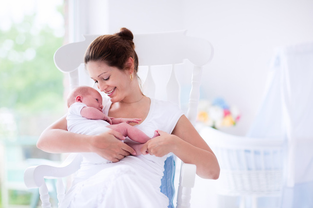 Fiatal anya és az újszülött fehér hálószoba - Fotó, kép