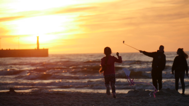 Mädchen Silhouette ist auf der Flucht mit Drachen Menschen Familien gehen Strand Sonnenuntergang Menschen fliegen die Drachen Internationale Drachenfestival Leba Pole - Filmmaterial, Video