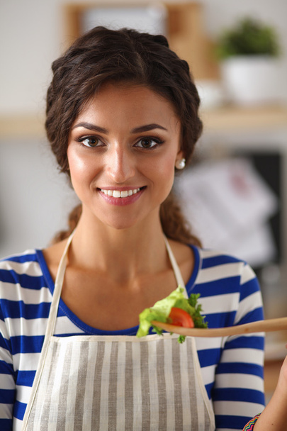 Smiling young woman in the kitchen, isolated on background - Fotoğraf, Görsel