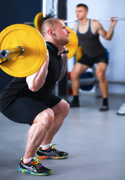 Shot of a young man performing bicep curls in a gym - Photo, Image