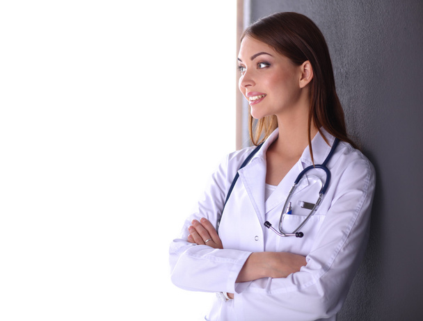 Portrait of a beautiful doctor leaning against the wall and looking at smth - Foto, immagini