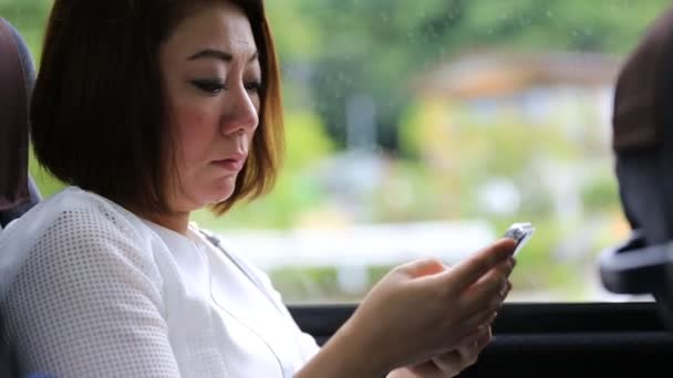 Young asian woman using smartphone while riding bus . - Materiał filmowy, wideo