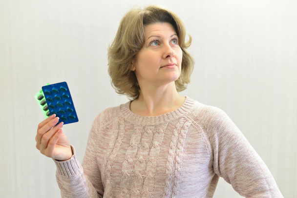 Adult woman holding  blister pack of a pills - Foto, imagen