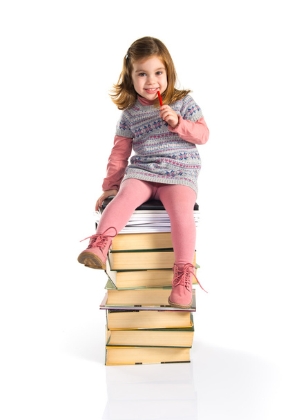 Menina sentada em livros
 - Foto, Imagem