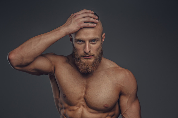 muskulöser Mann mit Bart posiert - Foto, Bild