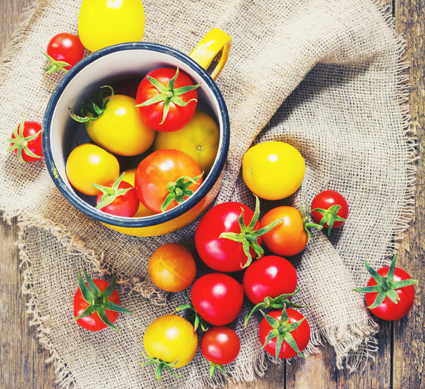 colorful tomatoes in a metal mug - Fotó, kép
