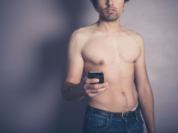 Young shirtless man with smartphone - Φωτογραφία, εικόνα