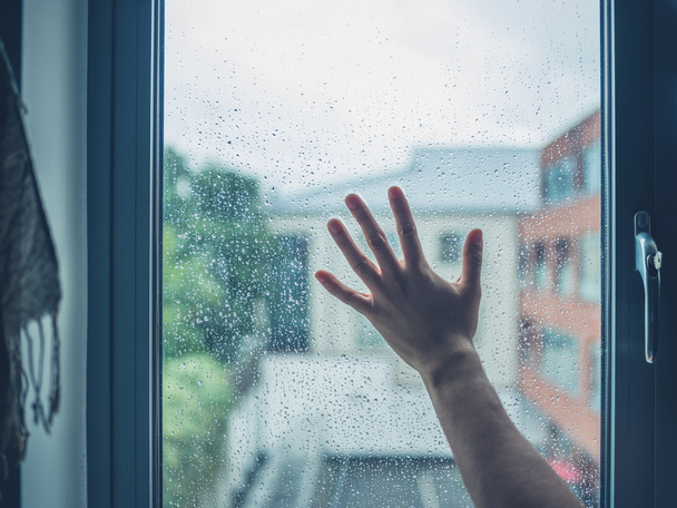 Young man's hand touching window with dew - Zdjęcie, obraz