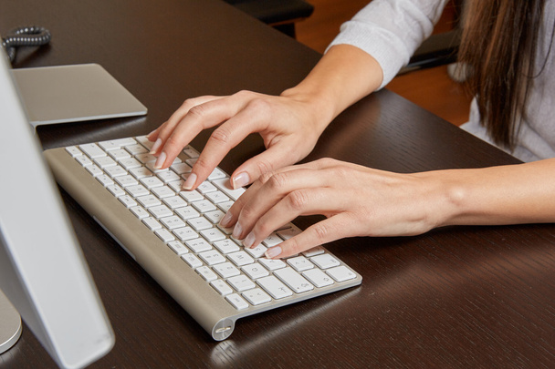 Nainen kirjoittaa tietokoneen näppäimistöllä
 - Valokuva, kuva