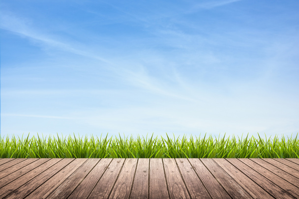 Houten vloer en gras onder hemel - Foto, afbeelding