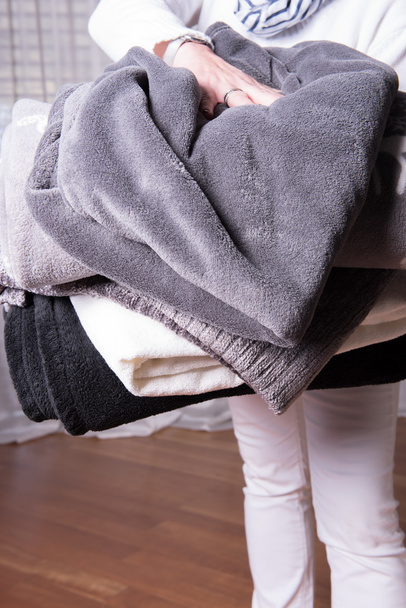 θηλυκό αρωγό χαιρετίζει πρόσφυγες με ζεστές κουβέρτες για κρύο σχεδόν - Φωτογραφία, εικόνα