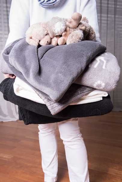 Женщина-помощник приветствует беженцев с теплыми одеялами для холодного близко
 - Фото, изображение