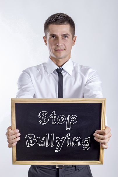 Stop Bullying - Young businessman holding chalkboard - Fotoğraf, Görsel