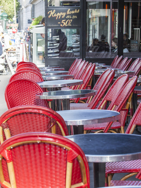 PARIS, FRANCE, on AUGUST 26, 2015. Picturesque summer cafe on the city street, red wattled chairs - Zdjęcie, obraz