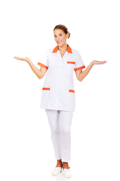 Uśmiechnięta kobieta lekarz lub pielęgniarka wskazując na coś - Zdjęcie, obraz