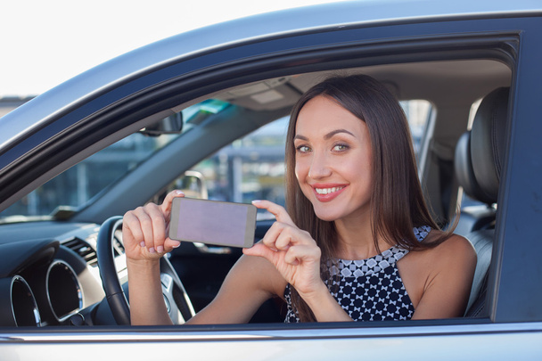 Beautiful female driver is making photos on telephone - Foto, imagen