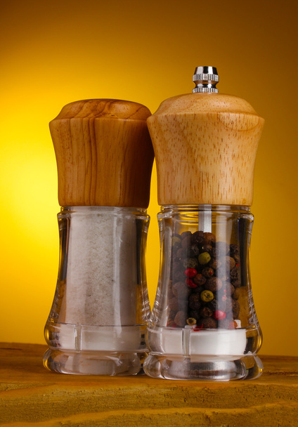Salt and pepper mills on yellow - Photo, image