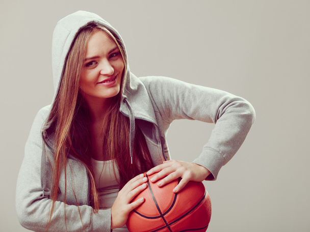 Sporty teen girl holding basketball. - 写真・画像