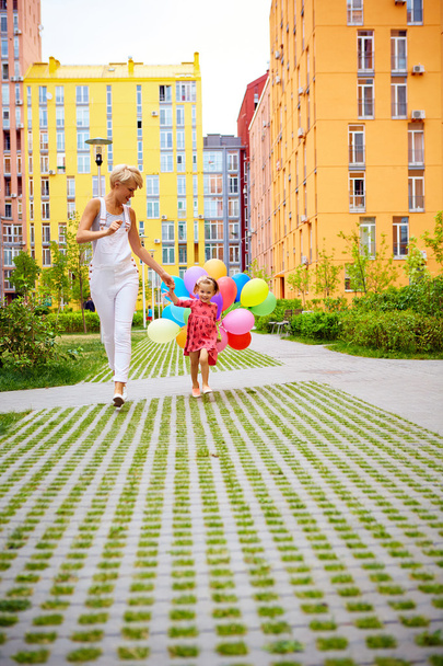 mother and child with colorful balloons - Foto, Imagen