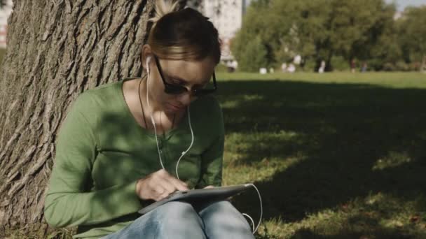 Chica en el parque y el uso de la tableta PC
 - Imágenes, Vídeo