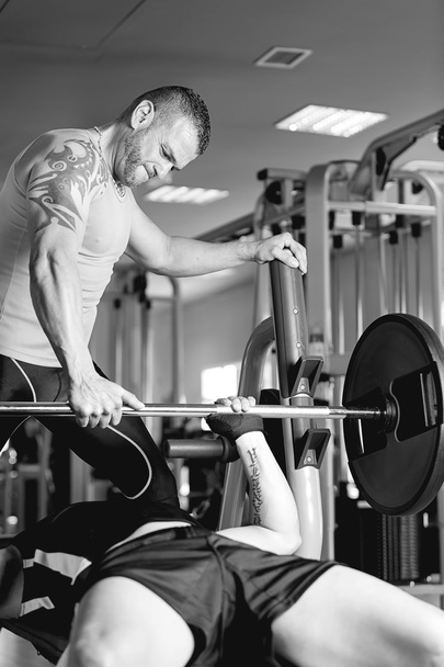 personal trainer helping a man with barbell - Photo, Image
