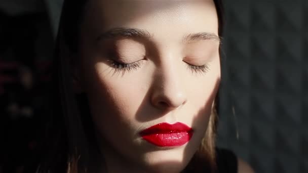 Viettelevä nuori nainen yllään punainen huulipuna katselee kameraa
 - Materiaali, video