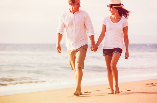 пара гуляє на пляжі на заході сонця
 - Фото, зображення