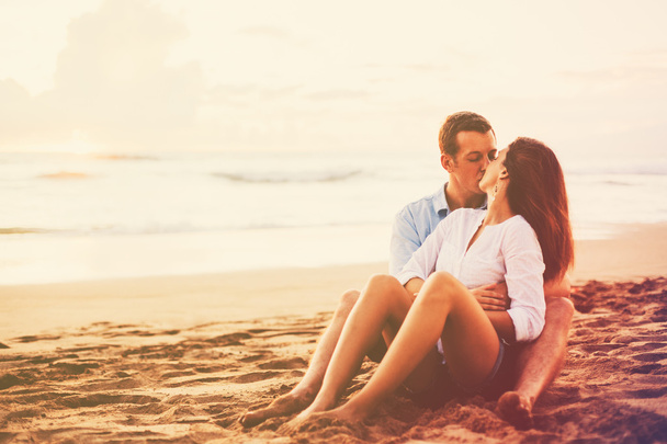 Pareja romántica disfrutando de la hermosa puesta de sol en la playa
 - Foto, imagen