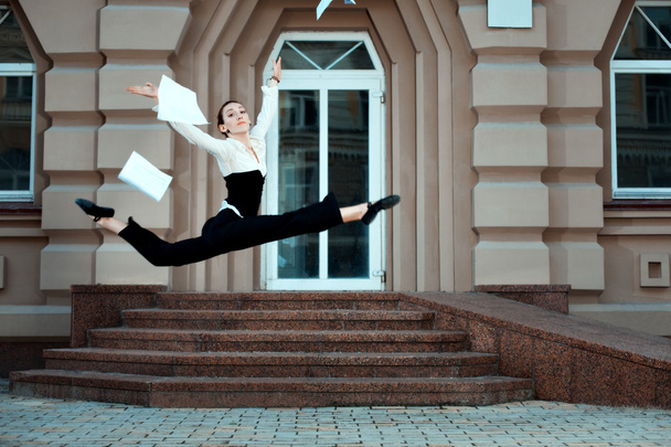Girl running down the street tossing documents handed. - Фото, изображение