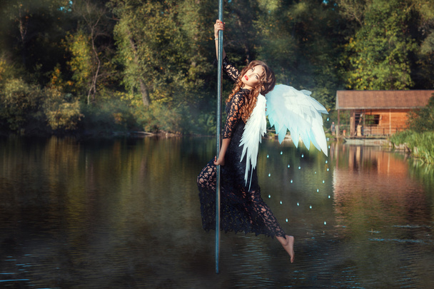Chica con alas de ángel bailando en el poste
. - Foto, imagen